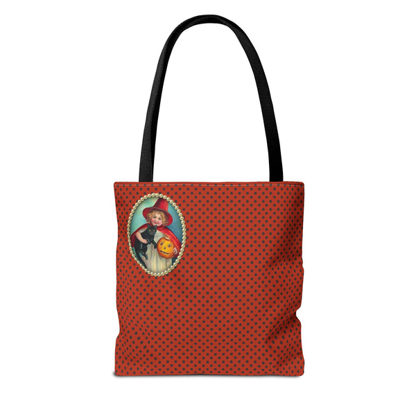 back side of A Halloween tote bag featuring a vintage-style illustration of a young girl in a red witch costume holding a black cat and a jack-o-lantern, framed by pearls on a polka-dot orange background.