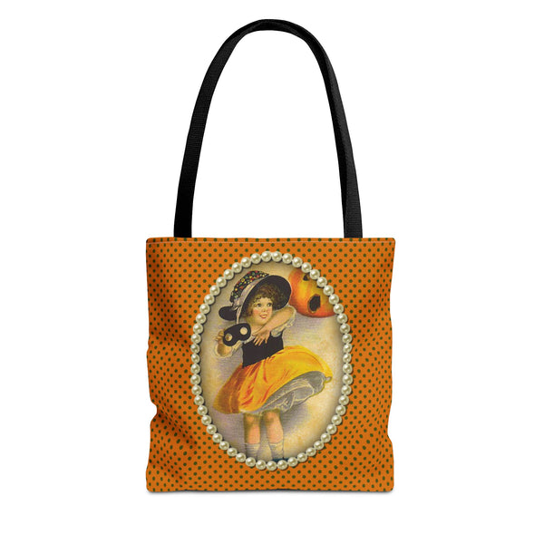 Vintage-inspired Halloween tote bag featuring an illustration of a young girl in a witch costume, framed with pearls on a polka dot orange background,