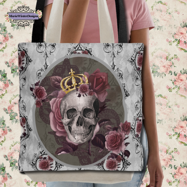 Person carrying a Tote bag with black handle and design of a gray skull with gold crown and roses on a gray background with back scroll lines and burgundy flowers