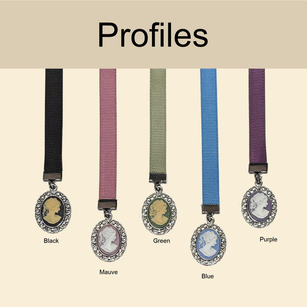 Five ribbon necklaces labeled Black, Mauve, Green, Blue, and Purple, each with a cameo-style oval pendant and rhinestone border, shown against a light beige background under the heading 'Profiles'.