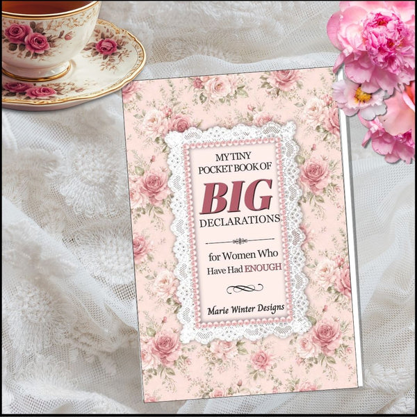A floral pocket book titled "My Tiny Pocket Book of Big Declarations for Women Who Have Had ENOUGH" by Marie Winter Designs, styled on white lace fabric with a teacup and flowers around it.