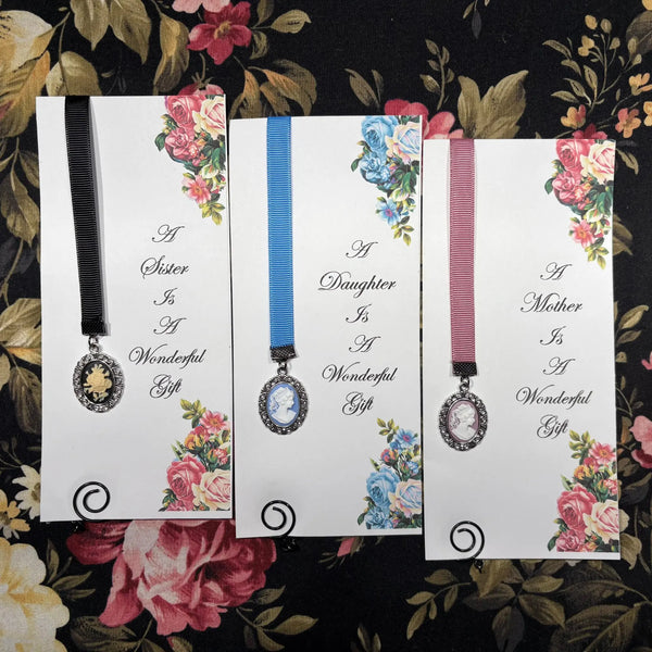 Vintage-inspired ribbon bookmarks with antique cameo pendants and floral artwork, handcrafted gifts for sisters, daughters, and mothers who love books, reading, journaling, and Bible study.
