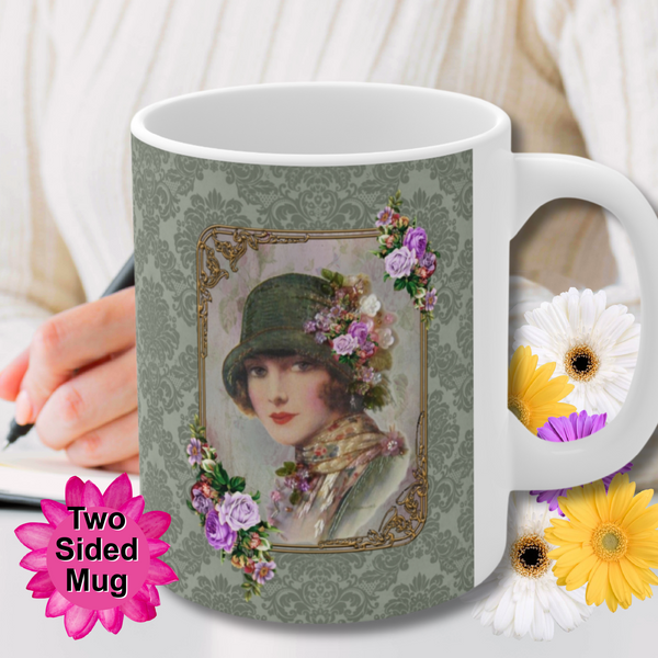 Ceramic Mug With Elegant 1920s Vintage Woman in Green Flapper Style Gatsby Hat surrounded by a gold art deco style frame accented with vintage purple flowers on green damask background with white handle. Pink flowers are behind the mug. Two sided mug. Stack of cookies and flowers are behind the mug. person holding pen and flowers are behind the mug