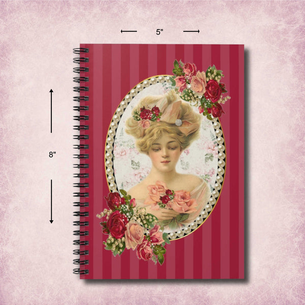 A spiral-bound notebook with a vintage-style cover illustration of a woman in an ornate hat and floral accents, set against a pink striped background. Black dimension arrows and labels indicate a height of 8 inches and a width of 5 inches.