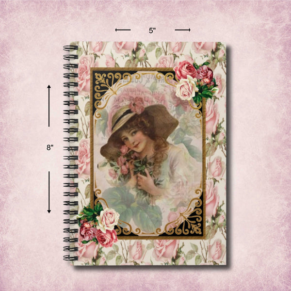 A spiral-bound notebook with a vintage-style floral cover design, shown with dimension arrows indicating 5 inches wide by 8 inches tall on a soft pink textured background.