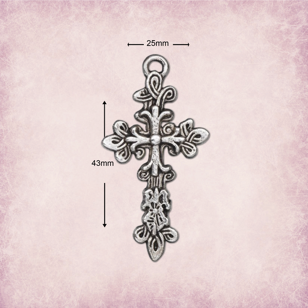 An ornate silver-toned cross pendant with decorative filigree details, shown on a textured pink background with dimension arrows and labels indicating 25mm width and 43mm height.
