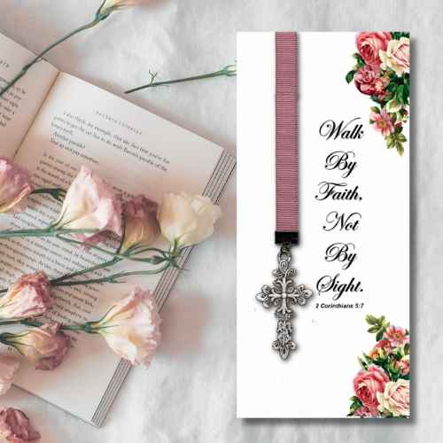A religious bookmark card with the scripture 'Walk By Faith, Not By Sight. 2 Corinthians 5:20' in black script, decorated with pink and green floral corners and a silver cross charm on a pink ribbon.