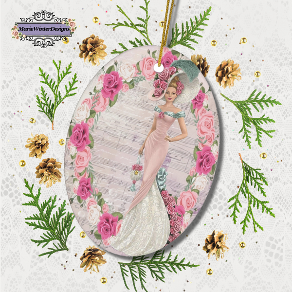 Oval ceramic ornament with Edwardian Lady with large hat music sheet background surrounded with pink and white roses laying on white lace surrounded with gold pine cones and greenery. 