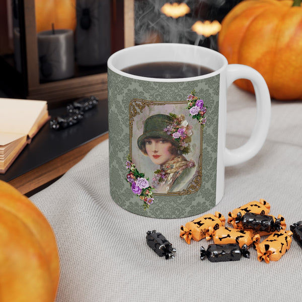 Ceramic Mug With Elegant  1920s Vintage Woman in Green Flapper Style Gatsby Hat with purple flowers on green damask background with white handle with a pupmkin in the distance and halloween candy in front