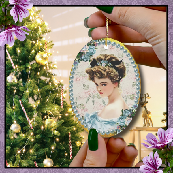 Hands with green nail polish holding an oval Ceramic Ornament With Elegant Early 1900s Vintage Harrison Fisher Illustration of Lady with Blue Flowers Surrounded with Blue Pearls with Christmas Tree in background